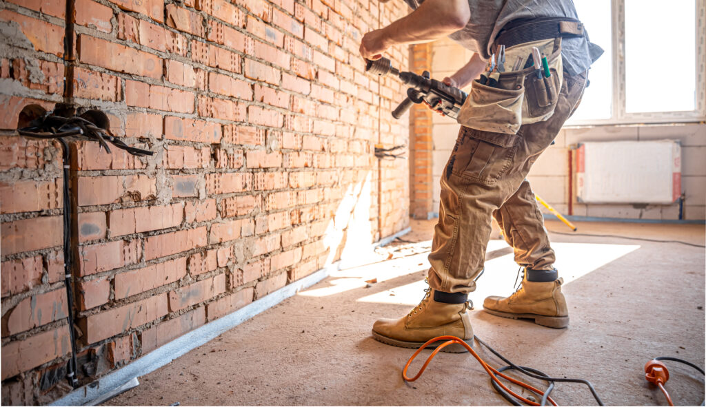 The builder works with a drill in working form.